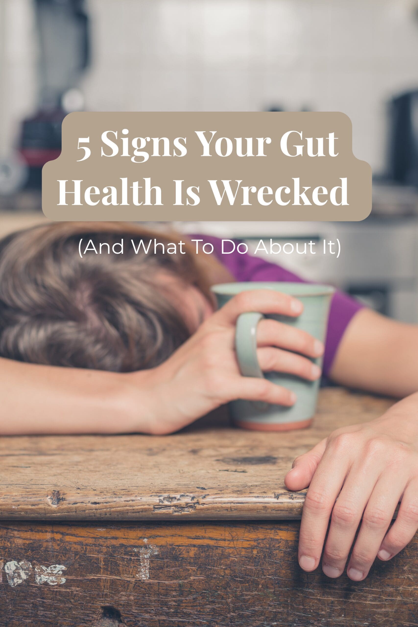 tired mom sitting at kitchen table with coffee with text overlay that reads 5 signs your gut health is wrecked